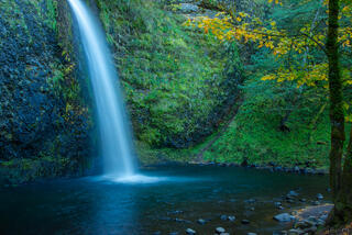 Color fine art photo of Horsetail Falls dropping into a luminous blue-green pool, moss-covered basalt walls and autumn maple, Columbia River Gorge, Oregon.