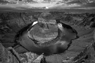 Black & white photograph of Horseshoe Bend with Colorado River carving through layered sandstone under dramatic sky, fine art landscape Photography Print.