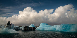 Jökulsárlón Glacier Lagoon fine art print featuring blue icebergs floating beneath dramatic clouds in Iceland"
