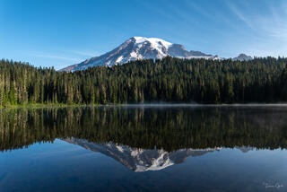 Limited edition fine art print of Mount Rainier reflected at Reflection Lakes. Still morning waters, rising mist. ChromaLuxe metal and TruLife Acrylic.