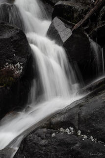 Limited Edition photography print of a waterfall with the white water dramatically contrasting the black rocks it flows over. Shown in large format.