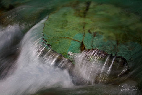 Tranquility, is a fine art limited edition print of water cascading over the equal colored rocks of a stream in Glacier National Park.