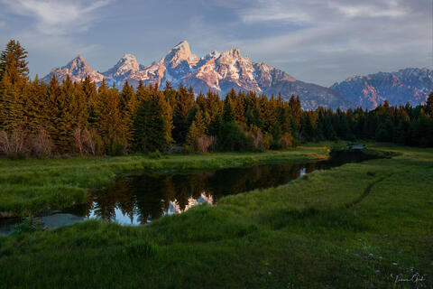 Alpenglow on the Teton Range reflected in a still beaver pond at Schwabacher's Landing, Grand Teton National Park.
