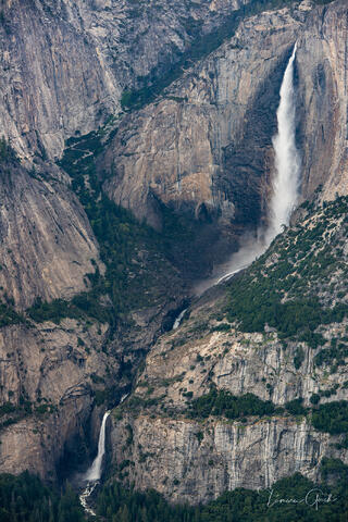 Upper and lower Yosemite Falls thundering down granite cliff face in spring snowmelt, compressed telephoto view, California landscape fine art photography