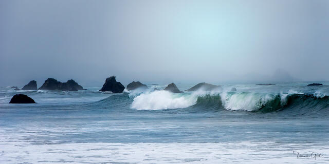 Brookings Oregon sea stacks emerging from fog, turquoise-green wave breaking in foreground, misty panoramic coastal fine art photography by Tamara Gooch.
