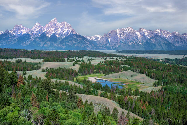 Color fine art photo of the full Teton Range above the forested Jackson Hole valley from a private elevated vantage, small oxbow pond below, Wyoming.